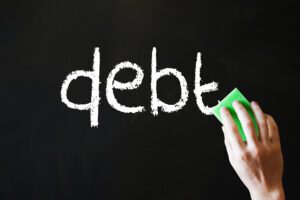 word debt on a chalkboard being erased