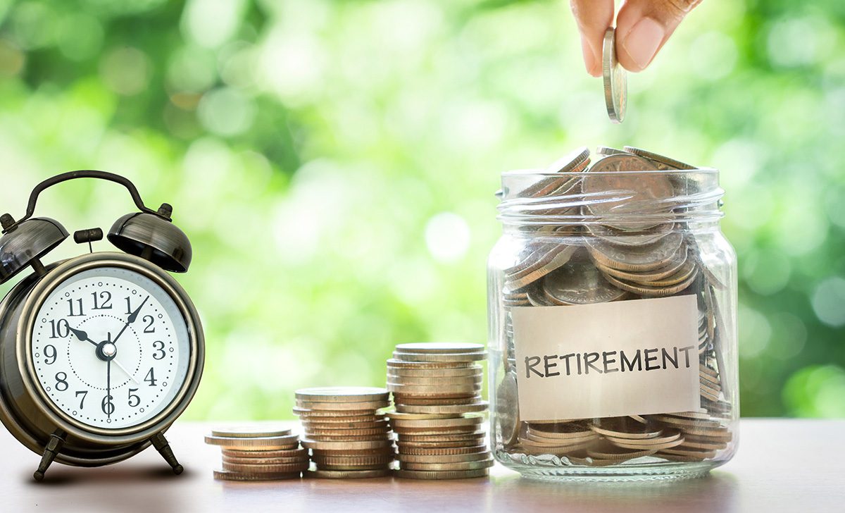 Hand Putting Coins In Glass Jar With Retro Alarm Clock